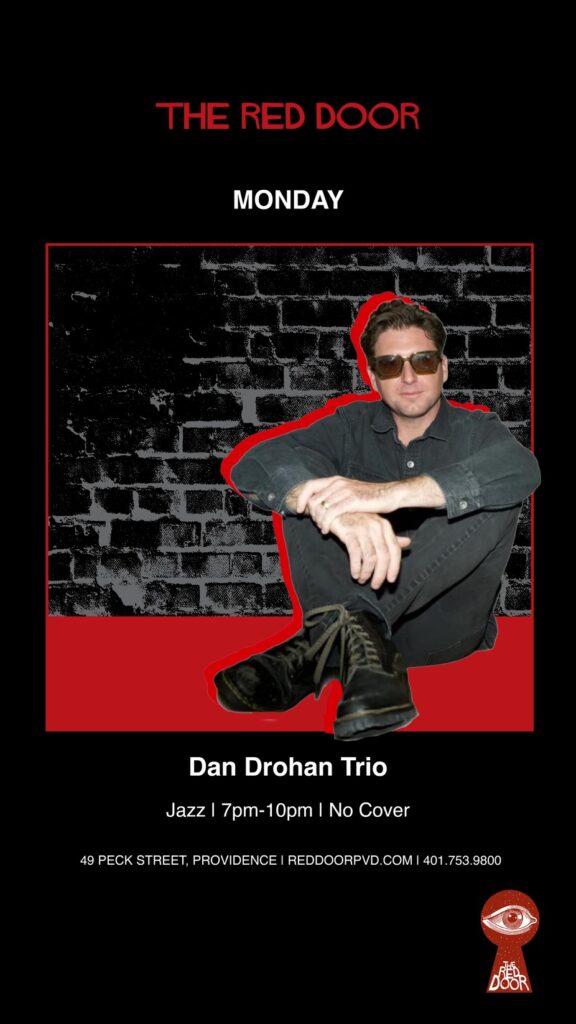 A man sits casually against a brick wall, promoting a jazz event featuring the Dan Drohan Trio.