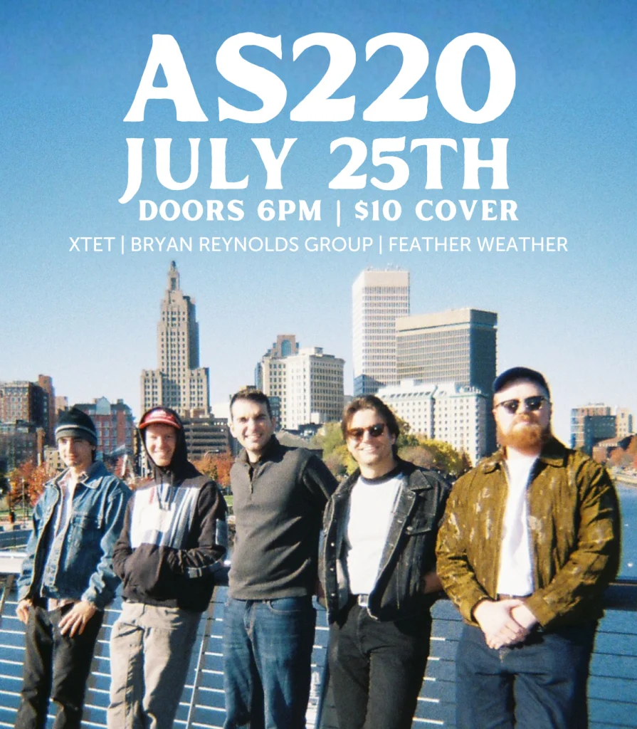 Five musicians pose together on a bridge with a city skyline in the background.