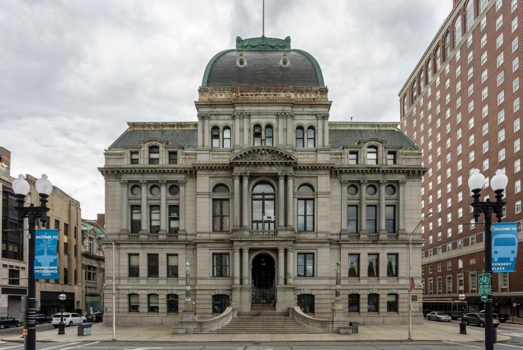 Historic building with ornate architecture, steps leading to the entrance, and nearby street signs.