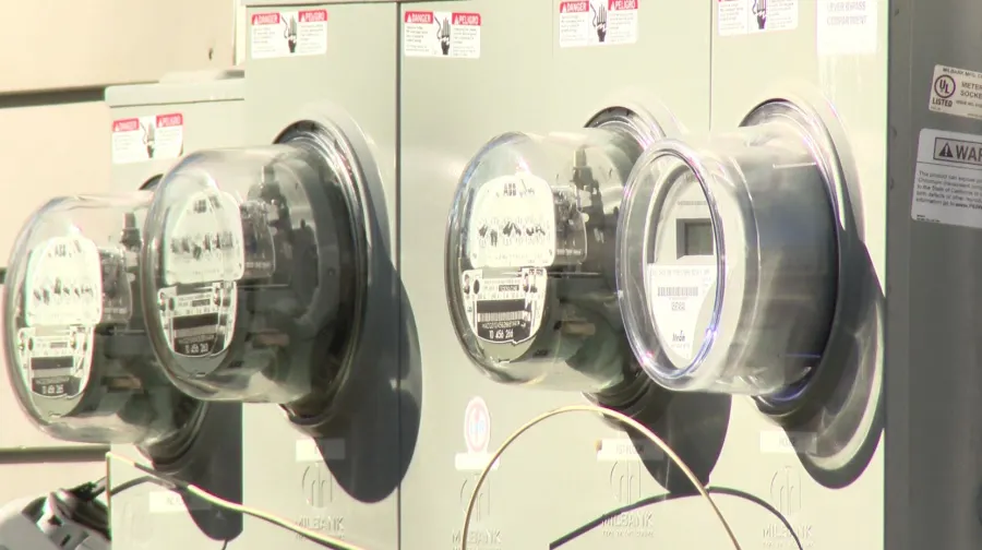 Several electric meters mounted on a wall, displaying dials and digital readouts.
