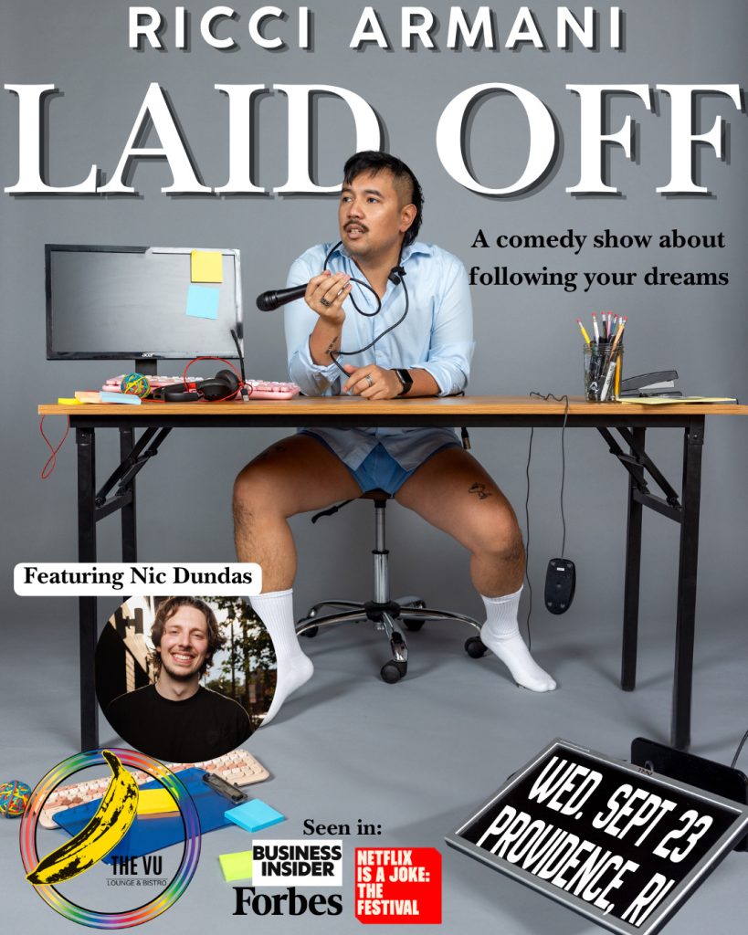 A man in a blue shirt and shorts sits at a desk with a microphone, promoting a comedy show titled "Laid Off.