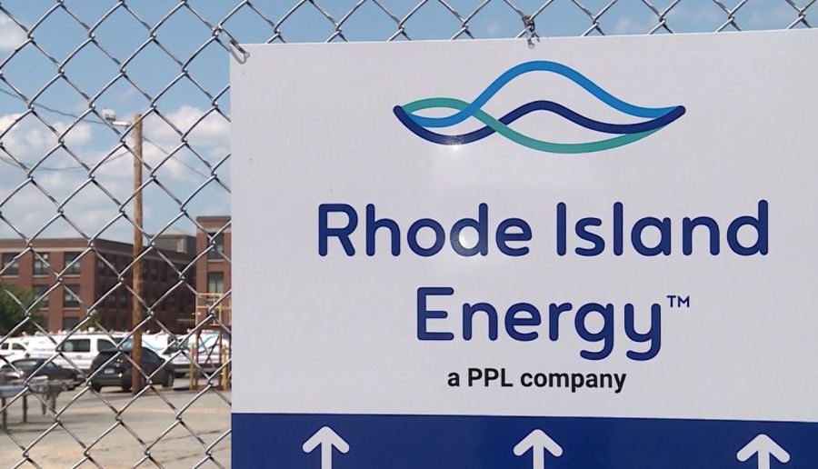 Sign for Rhode Island Energy, a PPL company, displayed on a chain-link fence.