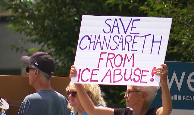 Protesters hold a sign reading "SAVE CHANSARETH FROM ICE ABUSE!" during a demonstration.