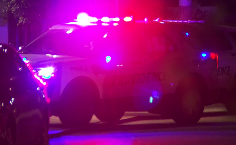 Police vehicle with flashing lights parked at night, creating a vibrant glow.