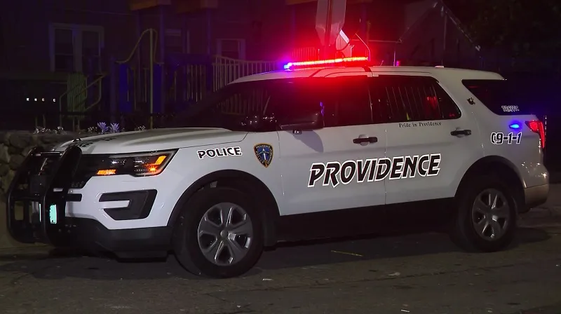Police vehicle parked with lights flashing, displaying "PROVIDENCE" on the side.