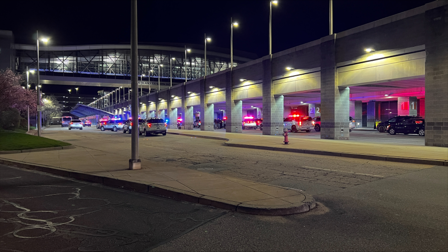Emergency vehicles with flashing lights are parked outside a building at night.