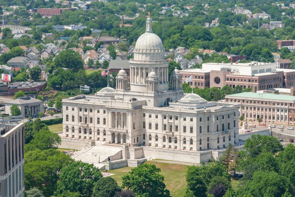 Aerial view of a large, historic government building surrounded by greenery and residential areas.