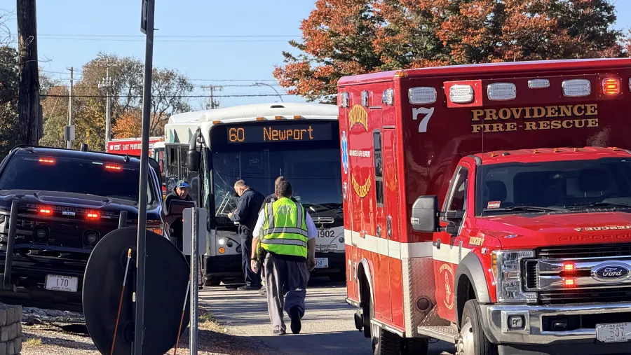 Emergency responders assist near a bus marked "60 Newport" and a fire rescue vehicle.