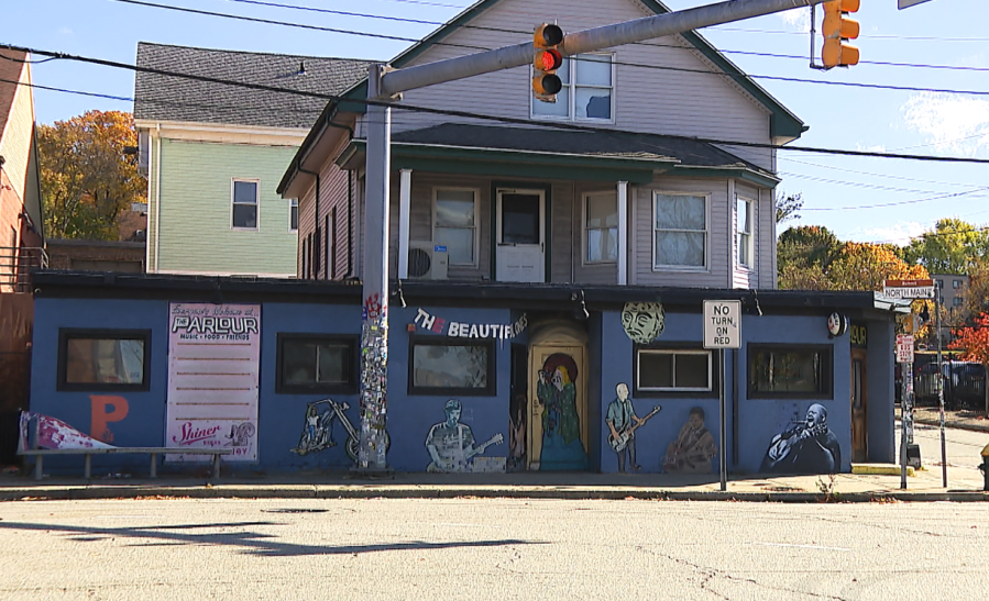A colorful mural decorates a building with music-themed artwork and a traffic light above.